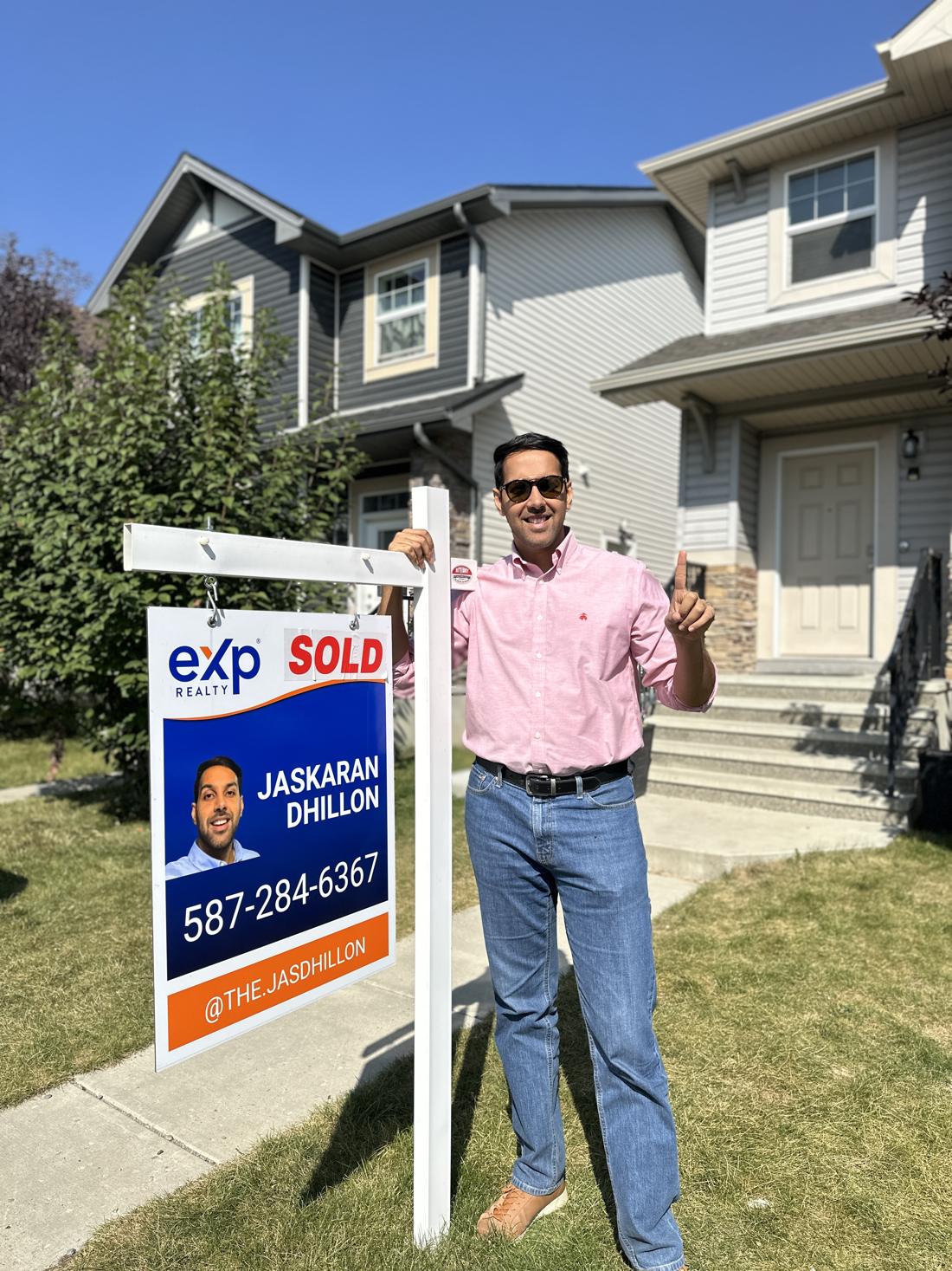 Jaskaran Singh Dhillon beside one of his SOLD signs