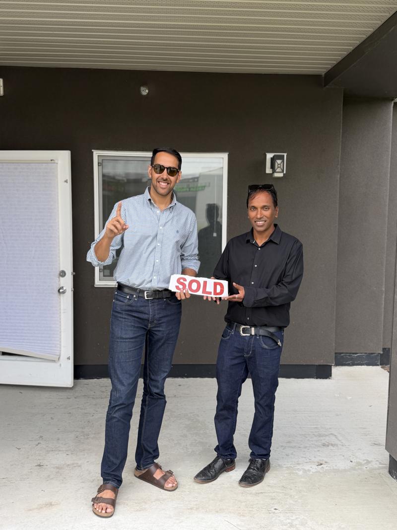 Jaskaran and a client holding a SOLD sign